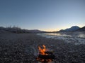 Warming fire on frozen cold white river shore