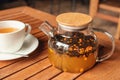 Warming tea with sea buckthorn in glass teapot in cafe. Warm tea in cold autumn or winter weather