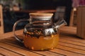 Warming tea with sea buckthorn in glass teapot in cafe. Warm tea in cold autumn or winter weather