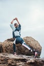 Warming up. Back view of sporty disabled athlete woman in sportswear with prosthetic leg standing in yoga pose on the Royalty Free Stock Photo