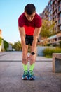 Warming-up before training. Man in sportswear standing on empty street, doing toe touching exercises before running Royalty Free Stock Photo