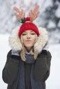 Warmly dressed woman blowing a kiss