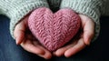 Warmth and Care: Hands Gently Holding a Knitted Heart Royalty Free Stock Photo