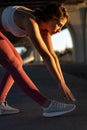 Warmup exercise before jogging: attractive female runner bend to leg warming up for running workout