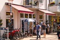 Warnemunde, Germany - June 8, 2018: A view of tourists walking past a souvenir shop and a rental bicycle stand on a sunny day in t