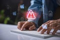 Warning alert icon with a hacked document system.Hands typing on a keyboard with a red cybersecurity threat alert, surrounded by