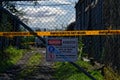 Warning, asbestos - a wire gate has a sign and tape warning of asbestos dust Royalty Free Stock Photo