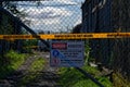 Warning, asbestos - a wire gate has a sign and tape warning of asbestos dust