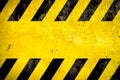 Warning background danger caution yellow black stripes painted over yellow concrete wall texture empty space text message Royalty Free Stock Photo