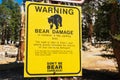 Warning bear damage sign informs tourists about possible car damage on parking lot while leaving food inside the vehicle