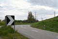 Warning black and white arrow traffic sign on sharp, dangerous road bend in a mountainous area. Royalty Free Stock Photo