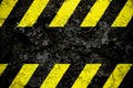 Warning danger sign yellow and black stripes pattern with black area over concrete cement wall facade peeling cracked paint.