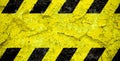 Warning danger sign yellow and black stripes pattern with yellow area over concrete cement wall facade peeling cracked paint