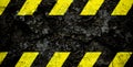 Warning danger sign yellow and black stripes pattern with black area over concrete cement wall facade peeling cracked paint. Royalty Free Stock Photo