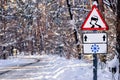 Warning due to wet, slippy road in winter snow forest