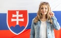 Warning finger up by blonde girl standing in front of flag of Slovakia