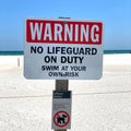 Warning No Lifeguard on Duty. Swim At Your Own Risk Sign.