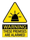 Warning, these premises are alarmed. Yellow triangle sign with symbol and text Royalty Free Stock Photo