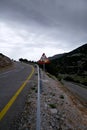 Warning road sign with bullet holes in the background of the mountain landscape of Crete Royalty Free Stock Photo