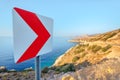 Road sign at the sharp turn of the serpentine and winding country road along the picturesque sea coast. Danger and risk of Royalty Free Stock Photo