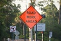 Warning roadworks sign and safety barrier on city street during maintenance repair work Royalty Free Stock Photo