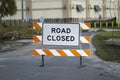 Warning roadworks sign and safety barrier on city street during maintenance repair work Royalty Free Stock Photo