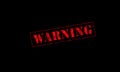 warning rubber stamp red on a black background Royalty Free Stock Photo