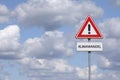 A warning sign against a cloudy sky Royalty Free Stock Photo