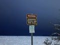 Warning Sign in Anchorage, Alaska saying Dangerous Waters and Mud Flats, Important Bird Area. Snowy field or harbor in winter Royalty Free Stock Photo