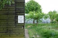 Warning sign attached to a wooden barn outer wall.