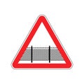 Warning sign attention with barbed wire fence. Note border on road. Road red symbol interdiction zone