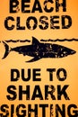 Warning sign: Beach closed due to shark sighting.
