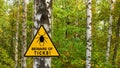 Warning sign beware of Ticks in infested area in birch forest Royalty Free Stock Photo