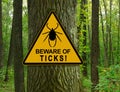 Warning sign beware of Ticks in infested area in oak forest Royalty Free Stock Photo