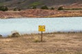 Warning sign on blue lake myvatn, iceland