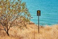 Warning sign cliff edge with a tree Royalty Free Stock Photo