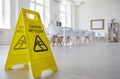 Yellow sign with the inscription Caution Wet Floor which was put in the office after cleaning. Royalty Free Stock Photo