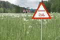 Warning sign: danger pollen allergy. family walking in the background Royalty Free Stock Photo