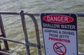 The Warning sign ` Danger Shallow water Jumping and Diving Prohibited` on a jetty.