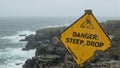 Warning sign Danger Steep Drop at cliffs edge by ocean rocks Royalty Free Stock Photo