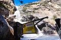 Warning sign due to Wapama Falls flowing over the footbridge and creating hazardous conditions for crossing; Hetch Hetchy Royalty Free Stock Photo