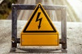 warning sign electricity on a bridge at a railroad track in sunshine Royalty Free Stock Photo