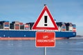 Warning sign with the German text `Luftverschmutzung` air pollution in front of a huge container ship. Royalty Free Stock Photo