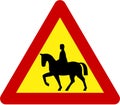 Warning sign with horse riders on road