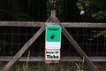 Warning sign for infected ticks in a forest. Risk of tick and Lyme disease Royalty Free Stock Photo