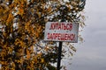 A warning sign installed on the beach of the forest lake. Sign restricts swimming. Translation: