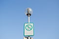 Warning sign on littering streets on street lamp