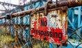 Warning sign No Trespassing mounted on a chain-link fence, with a weathered, bold red background, enforcing property boundaries Royalty Free Stock Photo