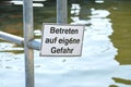 Warning sign at the quay edge in the port with German text, meaning Enter at your own risk, copy space in the water, selected Royalty Free Stock Photo