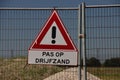 Warning sign for quicksand at construction site on fence Royalty Free Stock Photo